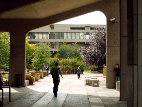 Walking underneath the archway of the Roger Stevens Building.