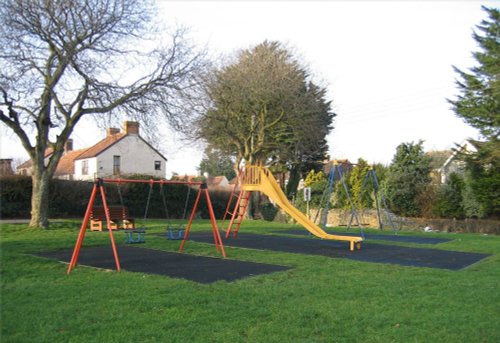 Childrens swings on the village green, Pawlett, Somerset.