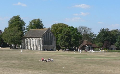 Guildhall museum in Priory Park, Chichester, with cricketers practicing before their match