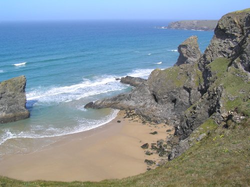 As the tide recedes at Bedruthan Steps, sandy coves are uncovered