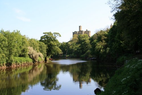 A view of Warkworth Castle from the river bank