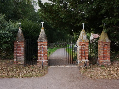 Gunton St. Peters Church gates next to the wood.