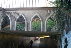 Wall Art in Exeter, with railings above and walker in tunnel beneath. Wallpaper