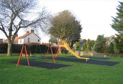 Childrens swings on the village green, Pawlett, Somerset. Wallpaper