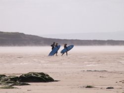 Surfers on steaming beach at Croyde in Devon 28/04/2006