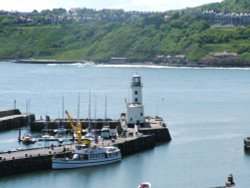 Scarborough, North Yorkshire. View over the harbour with lighthouse and the Coronia tour boat. Wallpaper