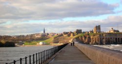 A couple walk hand in hand along Tynemouth Pier, Tynemouth, Tyne & Wear. Wallpaper