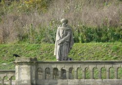 A Forlorn Statue With Only a Crow for Company Wallpaper