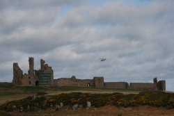 Dunstanburgh Castle with RNLI rescue helicopter Wallpaper