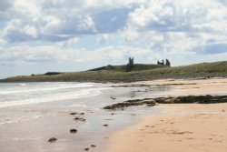 A view of Dunstanburgh Castle from the beach Wallpaper