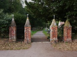 Gunton St. Peters Church gates next to the wood. Wallpaper