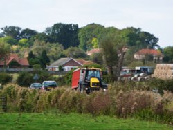 Tractor and Trailer winding it's way through the village Wallpaper