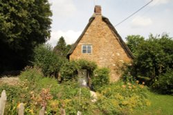 A traditional old cottage with its pretty cottage garden at Alkerton Wallpaper