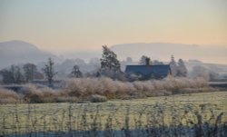 Cottage in a winter landscape at Brampton Bryan.. Wallpaper