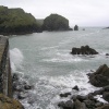 Waves break against the harbour wall at Mullion Cove, Cornwall