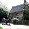 Pony and trap passing thatched cottage at Blickling Hall