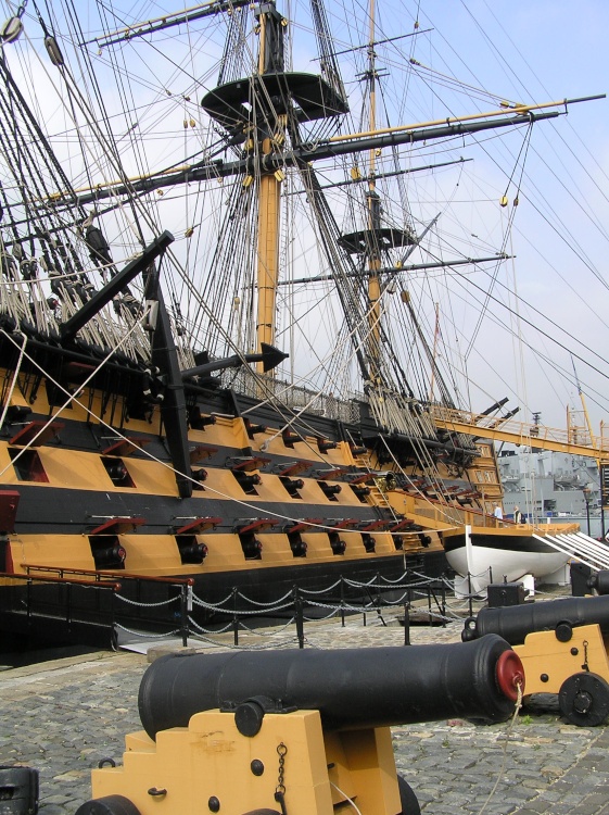 HMS Victory is guarded by a row of cannons along the dockside at Portsmouth, Hampshire