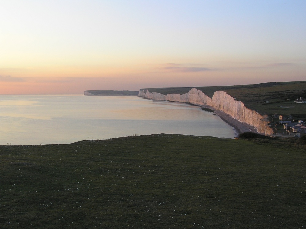 The Seven Sisters bathed in pink light at sunset, seen from Birling Gap