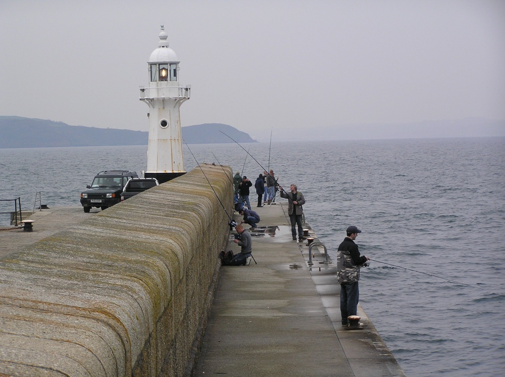 Anglers take advantage of an evening high tide at Mevagissey, Cornwall