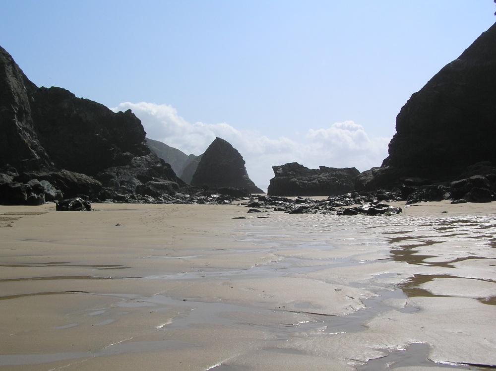 Brooding rocks and rivers of water on the beach at Bedruthan Steps, Cornwall, show the tide is never far away