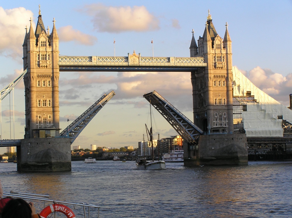 Tower Bridge opens to let through a masted ship