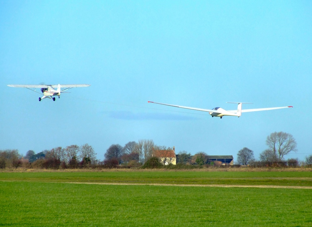 Glider being towed by Piper Super cub
