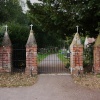 Gunton St. Peters Church gates next to the wood.