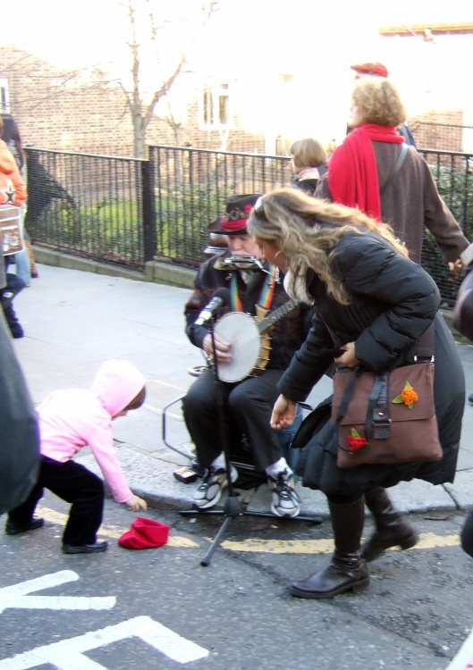 Greater London. Portobello Road. Cheering up the Busker.