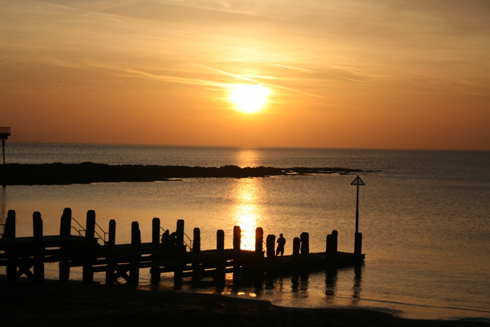 Sunset and Starlings massing over the sea